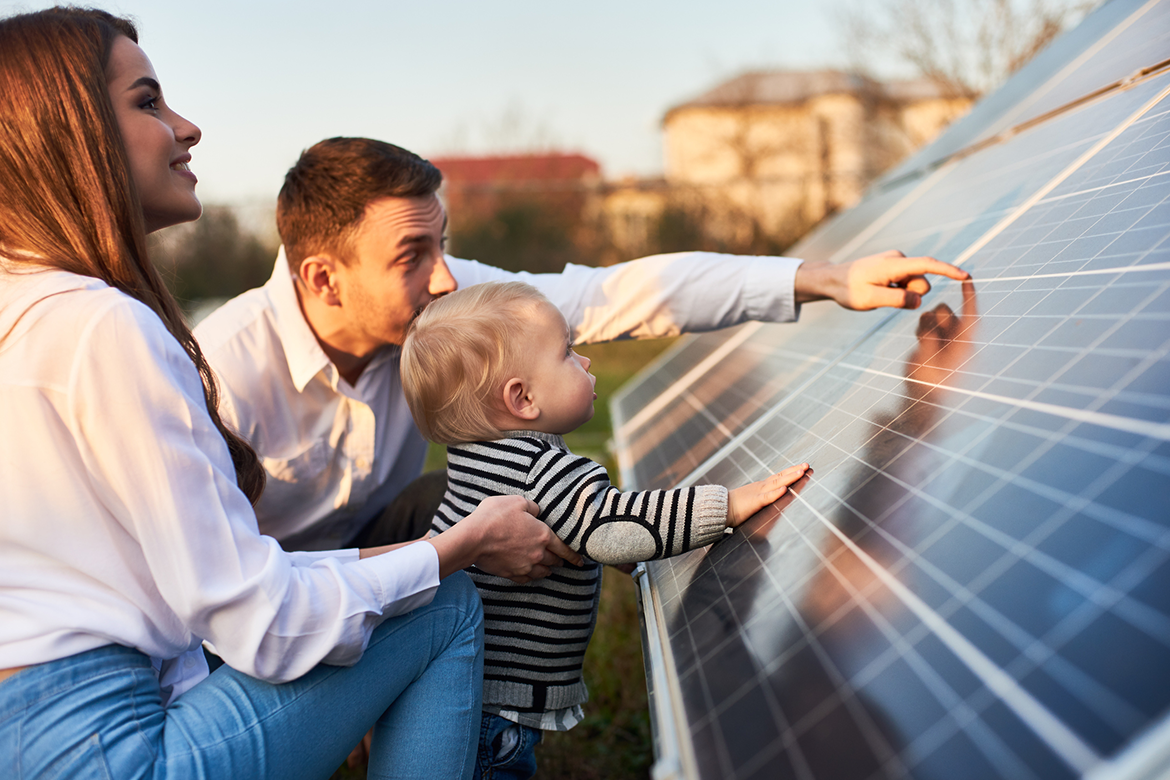 Family looking at energy saving solar panels on their home's roof