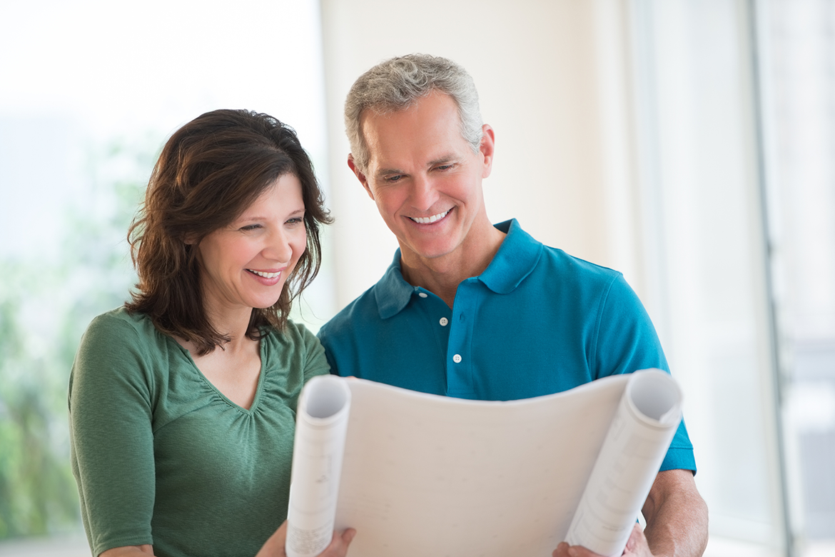 Middle-aged couple views blueprints for a home improvement project